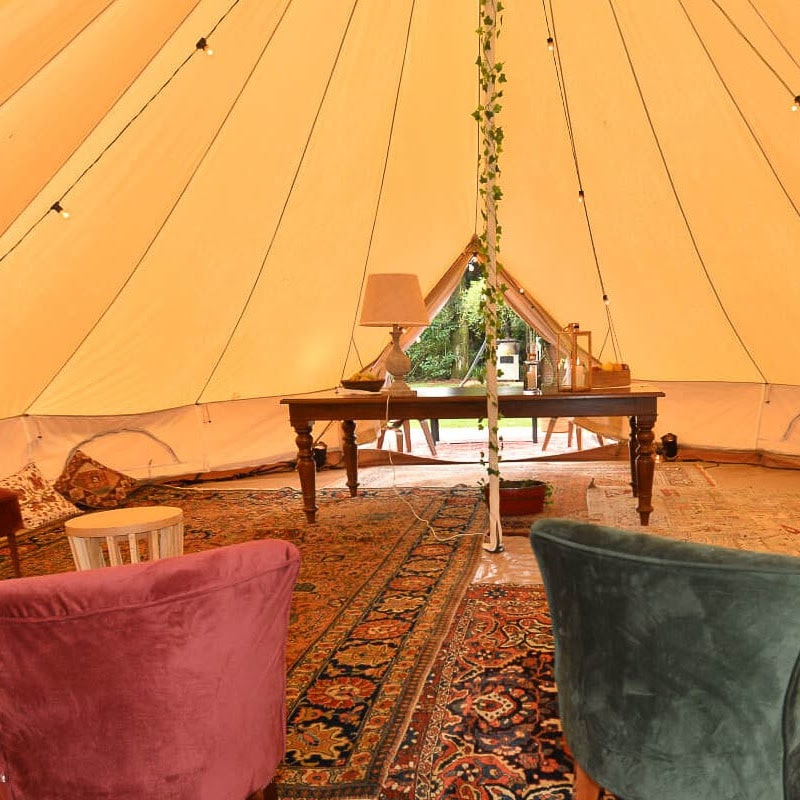 8 person bell tent Sibley 700 Ultimate Double Door interior view with table chairs and rugs inside