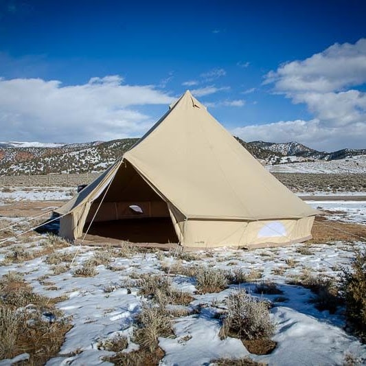 8 person tent Sibley 700 Protech Double Door set up in the snow with snowy mountains in the background