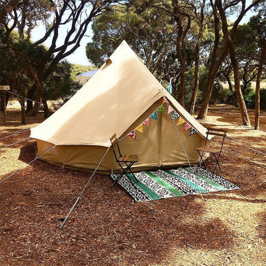 bell tent 4m Sibley 400 Pro in a campsite with chairs and a rug in front