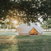 five person tent Sibley 600 Twin Ultimate with the sunrise visible through the tree leaves and dew on the grass