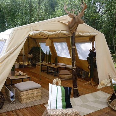 wall tent CanvasCamp Mess Tent III Canvas Cabin Tent set up over a wooden platform with rustic furniture